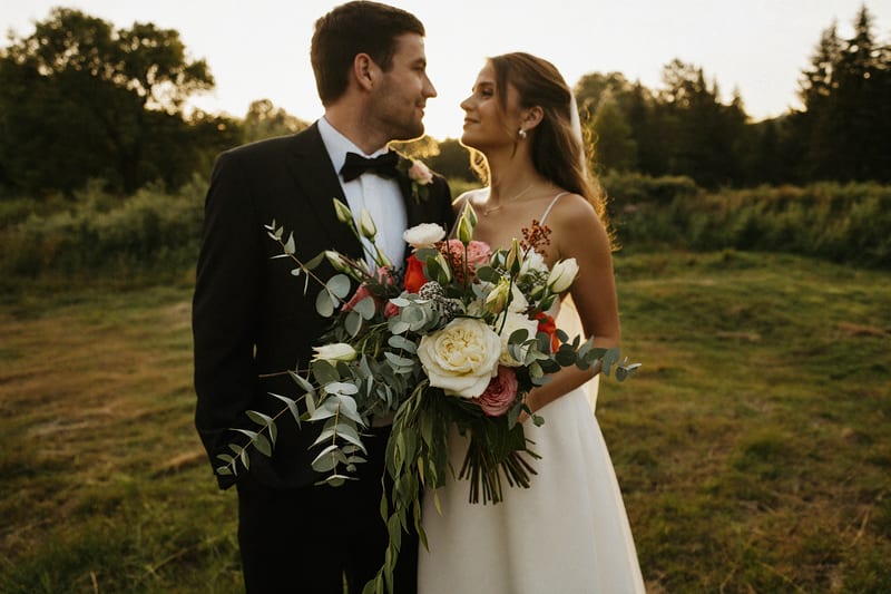Couple de mariés à contre-jour, gros bouquet au premier plan
