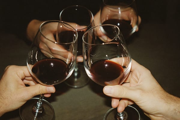 Mains qui trinquent, verres de vin, lumière tamisée